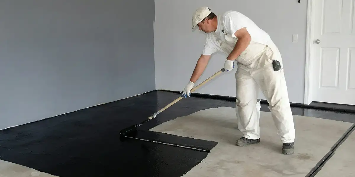 basement waterproofing professional applying waterproof coating to protect a basement floor in Richmond, VA