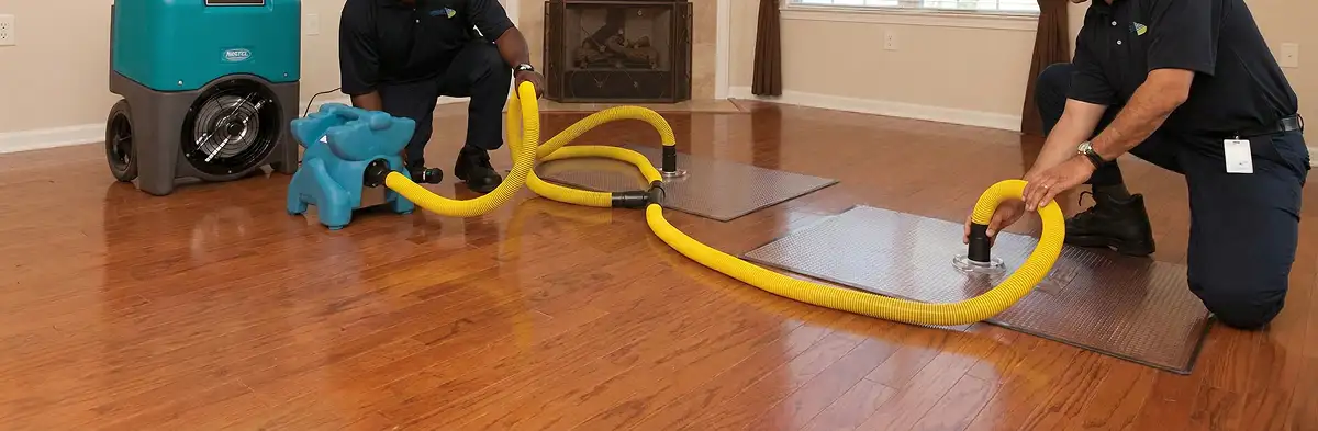 emergency water removal technicians extracting standing water from a home using professional equipment in Richmond, VA